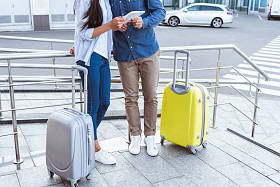 使用数字平板电脑的夫妇行李的裁剪视图