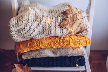 椅子上堆滿了各種各樣的毛衣圖片