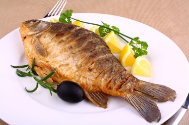 油炸的魚(yú)與檸檬、 叉子和刀的白板上