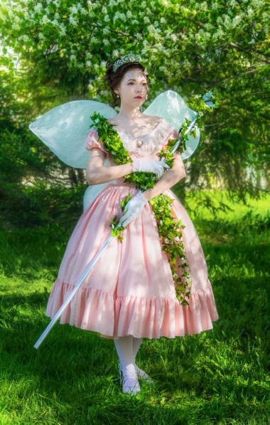 女孩在童話的圖片與魔杖的童話在花樹下的花園在夏天的陽光明媚的天