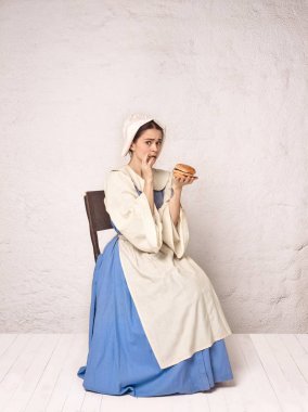 中世紀(jì)婦女穿緊身衣和帽子的歷史服裝.