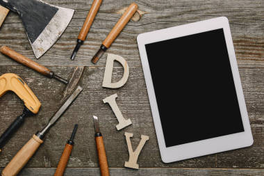 平面鋪設(shè)與數(shù)字平板電腦, diy 標(biāo)志和不同的木工工具在木制背景