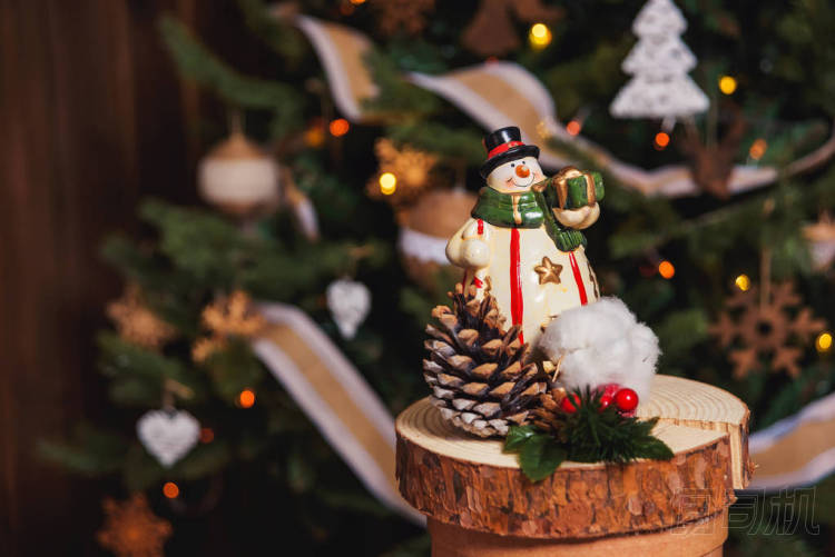 圣誕樹(shù)背景上的雪人。質(zhì)樸的圣誕裝飾品雪人的陶瓷雕像。木質(zhì)風(fēng)格的圣誕裝飾