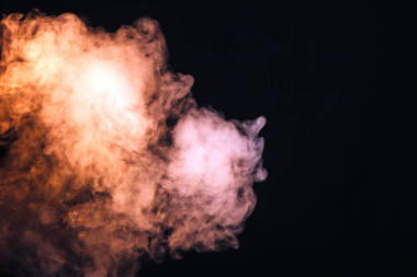 黑色背景上的有色煙霧。音樂會上燈光表演的概念