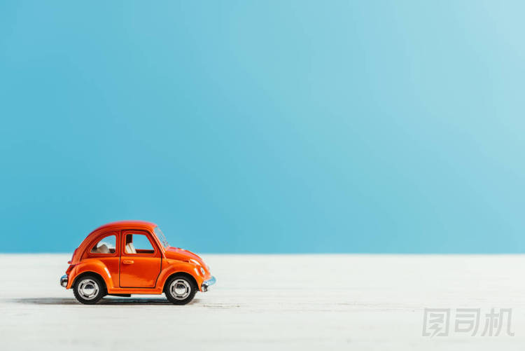 玩具紅色汽車的側(cè)視圖騎在白色表面在藍(lán)色背景