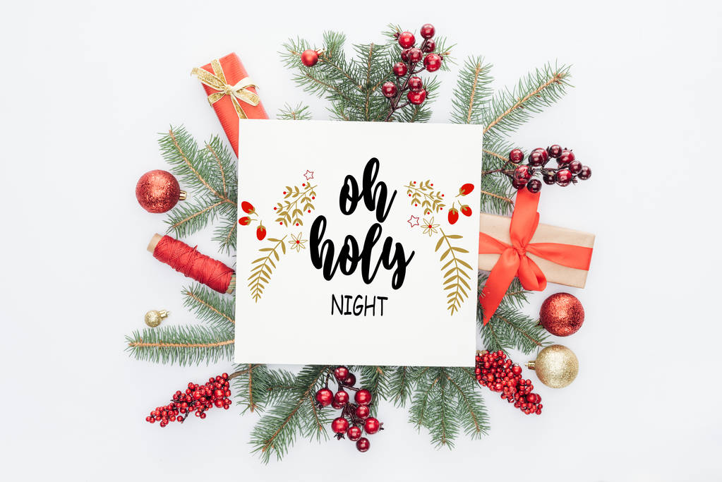 最高的松树树枝，圣诞装饰和礼物与“O Holy Night”的文字在中间被发现是白色的
