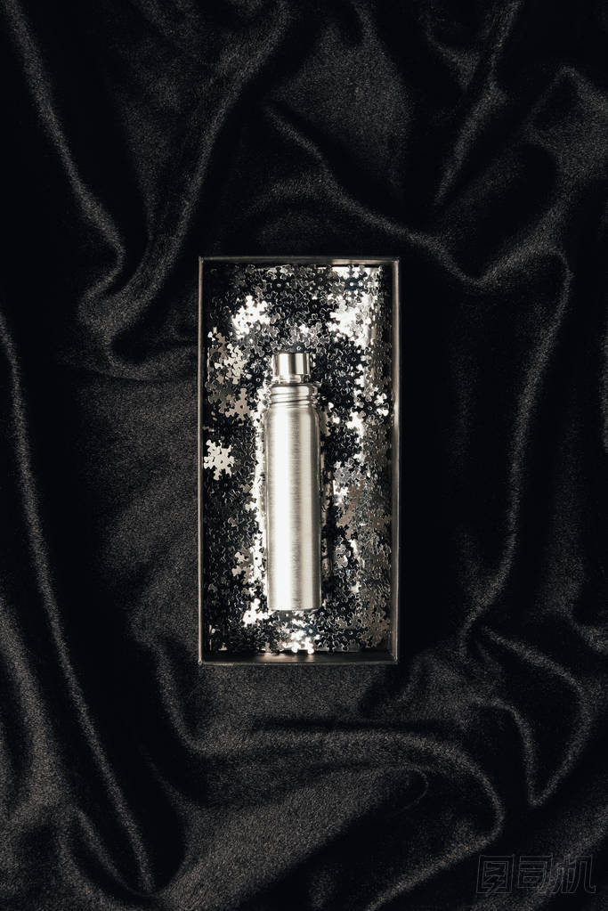 香水的最高視圖在盒子與閃亮的銀色裝飾雪花在黑色的織物 