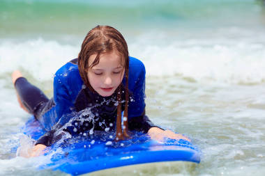 沖浪課程, 十幾歲的女孩學(xué)會沖浪在一個溫暖的沖浪服裝