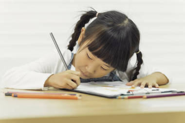 在學校的桌子上畫油漆的亞洲兒童