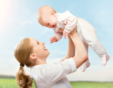 幸福的家庭。母亲吐在天空中的宝宝