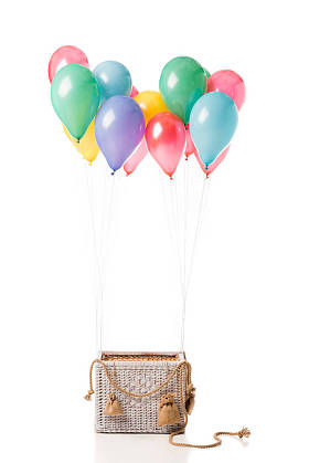 柳条篮子与五颜六色的气球隔离在白色