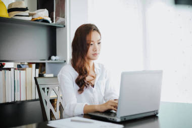 亚洲商界女性使用笔记本和微笑快乐工作 