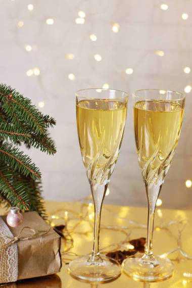圣誕樹旁邊的桌子上有兩杯香檳酒