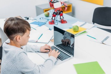 小學生在臺的筆記本電腦鍵盤上打字