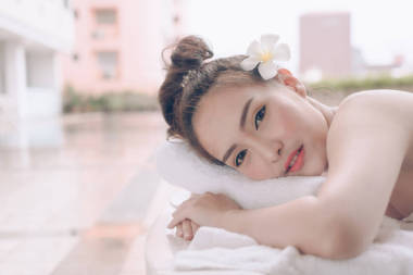 美麗的亞洲婦女放松與手按摩治療在美容 spa。年輕快樂的女孩在溫泉沙龍得到按摩。推拿療法療愈醫(yī)學(xué)與保健理念. 