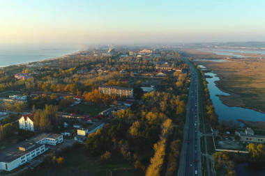 沿海城市的美丽的夜景与道路和潮湿的草地。航拍照片