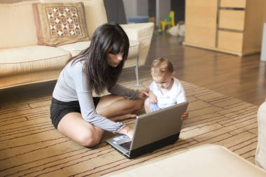 美麗的母親與她的寶寶看著筆記本電腦