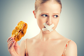 饮食的概念。女人嘴用包子用胶带密