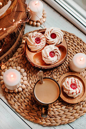 一杯咖啡, 里面有甜蛋糕、燃烧的蜡烛、木制的装饰和灯光