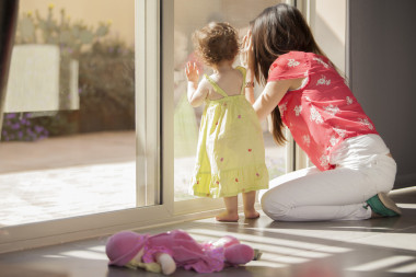 年輕的母親從與她的孩子的窗口看