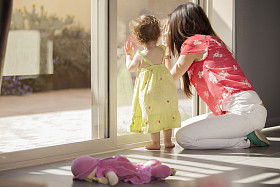 年轻的母亲从与她的孩子的窗口看