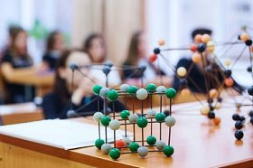 在具有分子模型的科学课上的小学生。具有软焦点的背景图像。教育理念