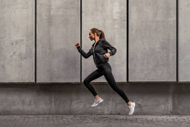 年輕運動員正在體育場附近跑步。側(cè)視圖