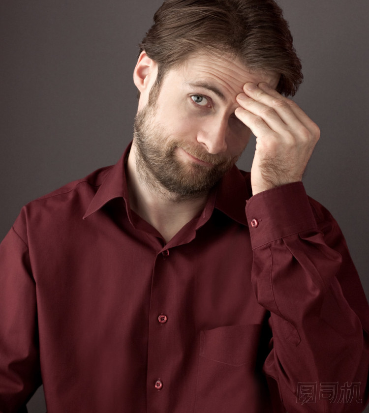 四十歲羞愧或感到困惑男人邊看著相機(jī)搔頭。關(guān)閉了灰色背景的肖像