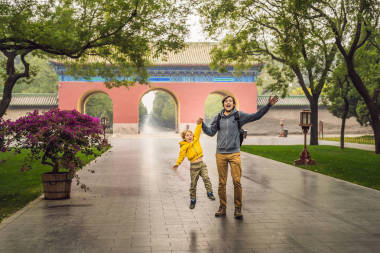 爸爸和兒子是中國(guó)大門背景下的游客。中國(guó)的兒童旅行理念
