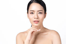 年轻的亚洲妇女与美丽的皮肤健康的面孔在白色背景查出