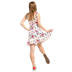 美丽的女人穿着鲜花打印和运动鞋显示积极的情绪运行快乐