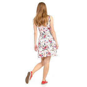 美丽的女人穿着鲜花打印和运动鞋显示积极的情绪去快乐