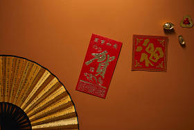 风扇的顶视图与象形文字和金黄装饰在棕色背景, 中国新年构成