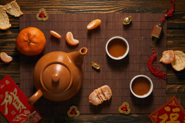 竹席上的茶具、橘子和中國(guó)傳統(tǒng)裝飾品的頂視圖
