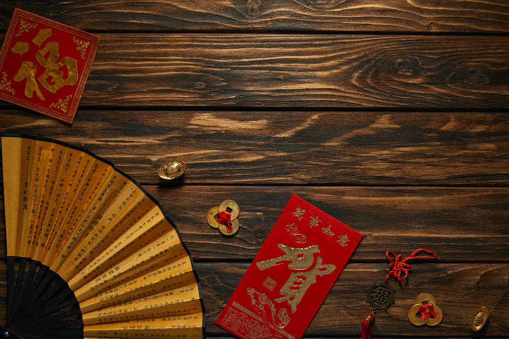中国新年组成的顶部视图与风扇, 象形文字和装饰金币在木制表面