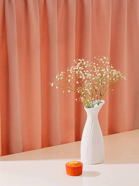 自制美味的纸杯蛋糕在桌上与花在花瓶