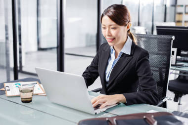 在辦公室的筆記本上工作的年輕女商人