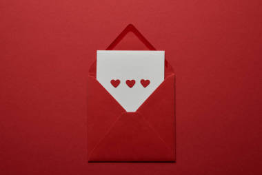 白色信件的顶部看法与心脏在信封在红色背景