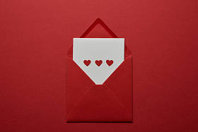 白色信件的顶部看法与心脏在信封在红色背景