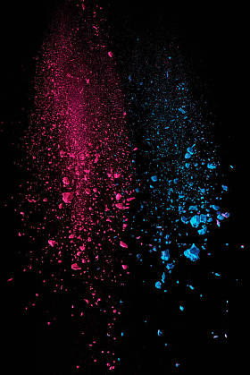  粉红色和蓝色的冬青粉在空气中的黑色背景