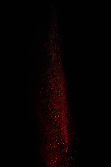  红色粉末在空气中, 落在黑色背景