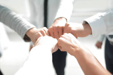 关门了商人和女商人在建筑背景上做拳头碰撞