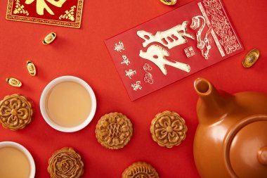 在紅色上隔離的中國象形文字和茶的傳統(tǒng)月餅的頂視圖