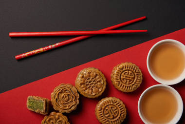 紅色和黑色背景上的傳統(tǒng)中國月餅與筷子的頂部視圖