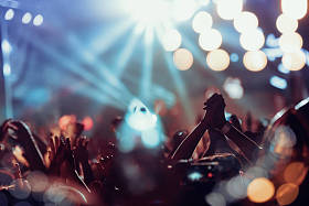 音乐会上的人群。在五颜六色的舞台灯光前欢呼的人群