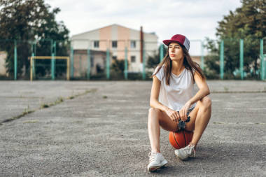 相當年輕運動的女孩與籃球室外