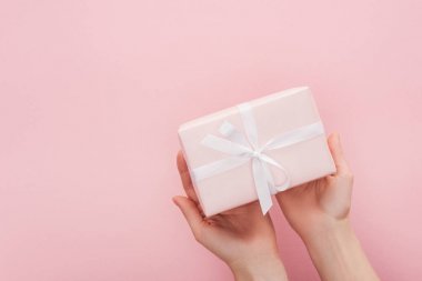 裁剪視圖的婦女舉行禮品盒隔離粉紅色與復(fù)制空間