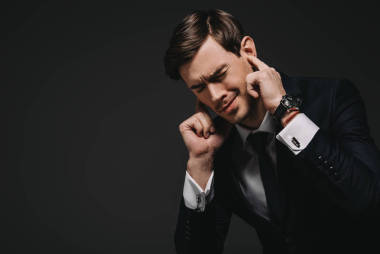 商人插在耳朵的手指隔离在黑色