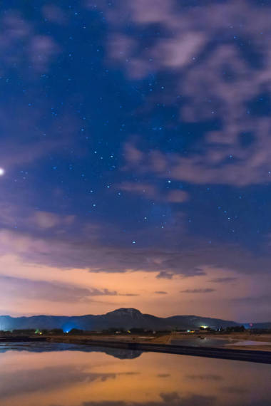 星空映照在水面上, 山頂上有一些云