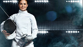 身穿击剑服装的年轻击剑运动员手持剑和面具。在黑色背景